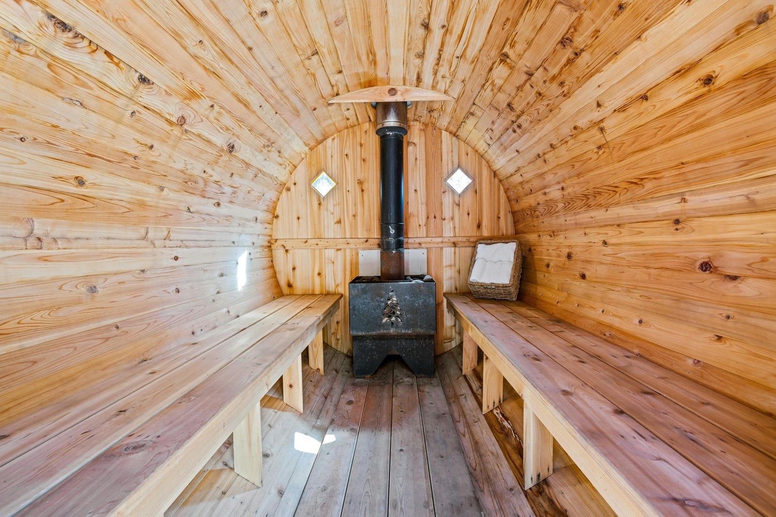 Barrel sauna interior with a wood-fired stove in Oakland